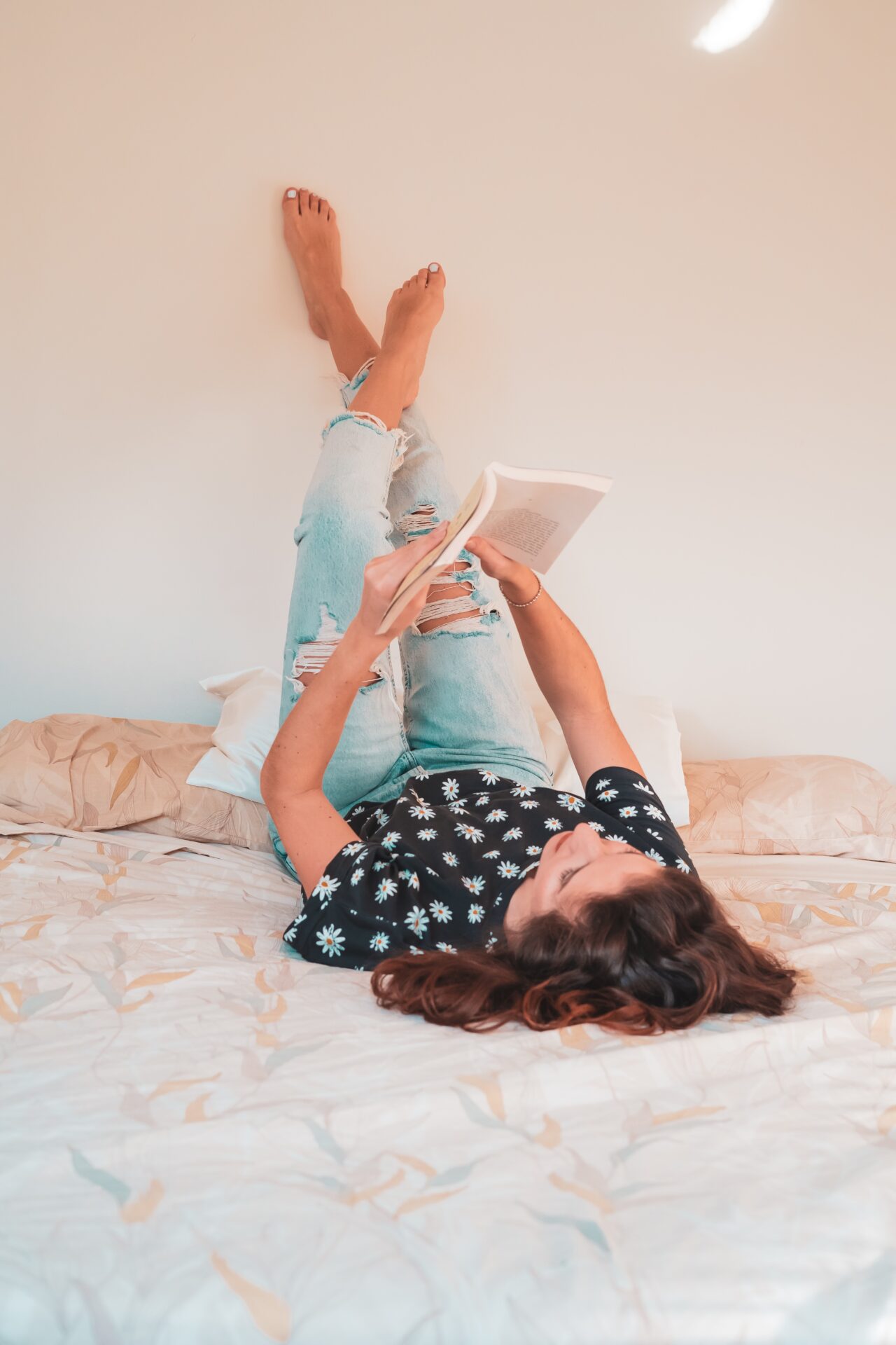 Woman relaxing in bed reading a book before going to sleep